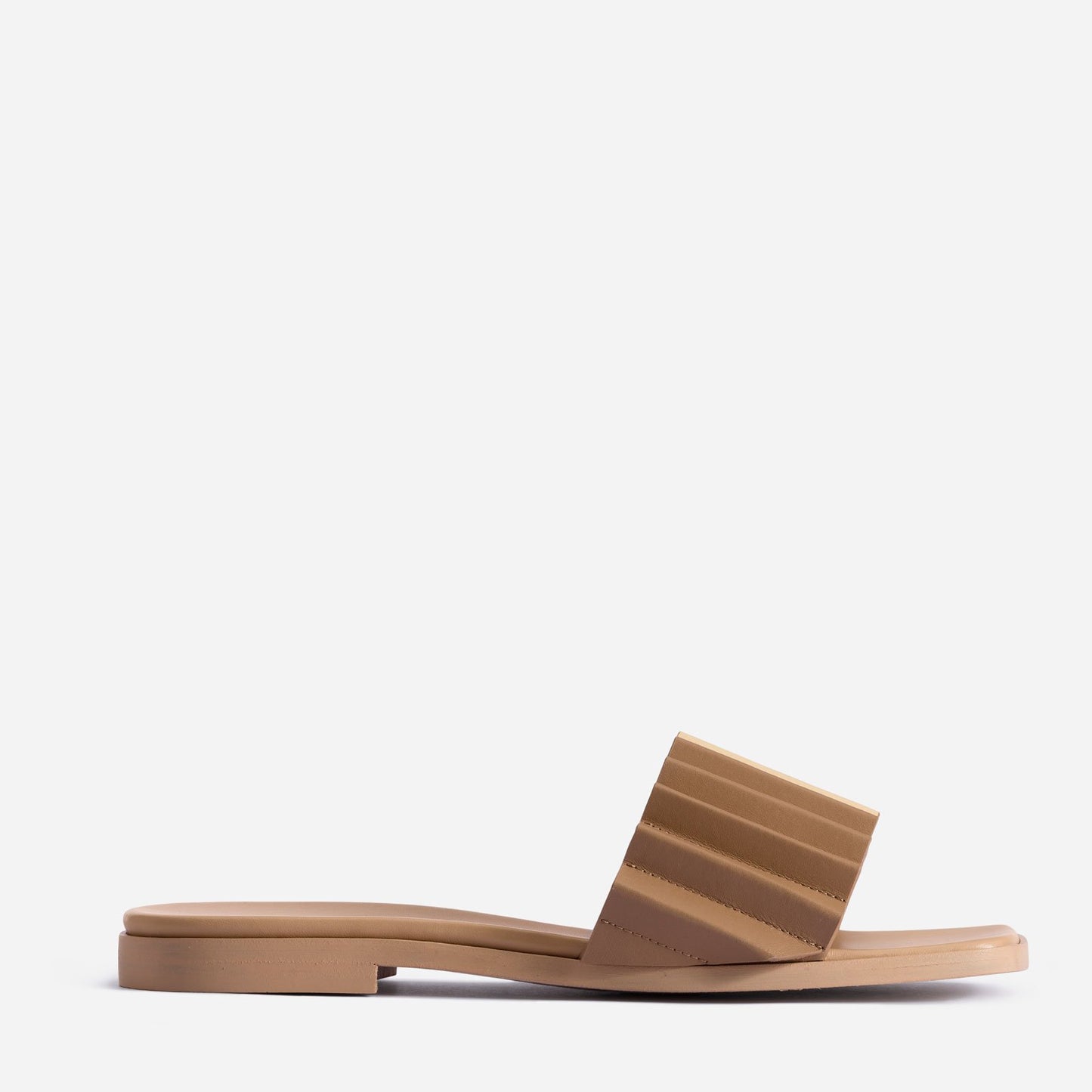 Side view of tan-brown sandal. Back of sandal is slightly raised via 1-inch heel. Wide, single strap across the middle-front features ridged design.